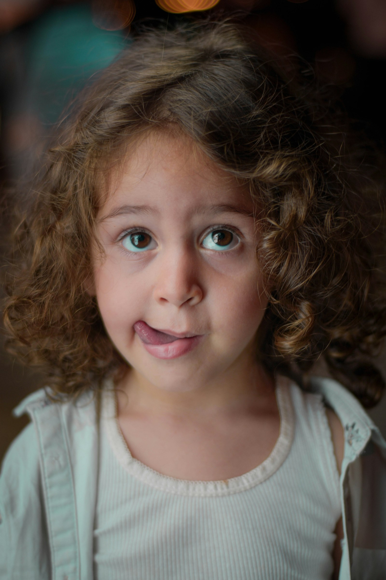 A young girl with curly hair looking into the camera, photographed in Armenia