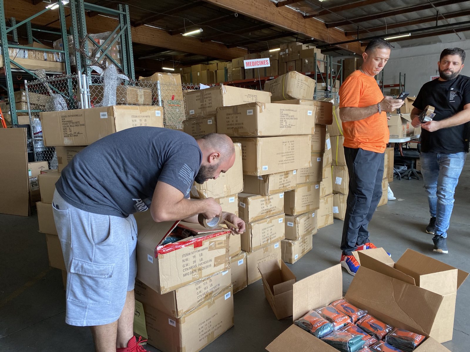 Volunteers sorting boxes of relief supplies in a warehouse