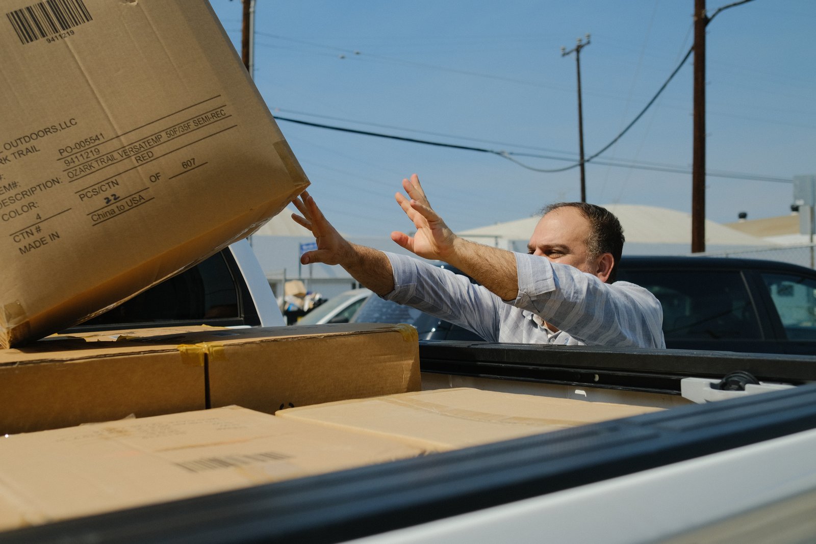 A volunteer reaching for a box of relief supplies on the truck