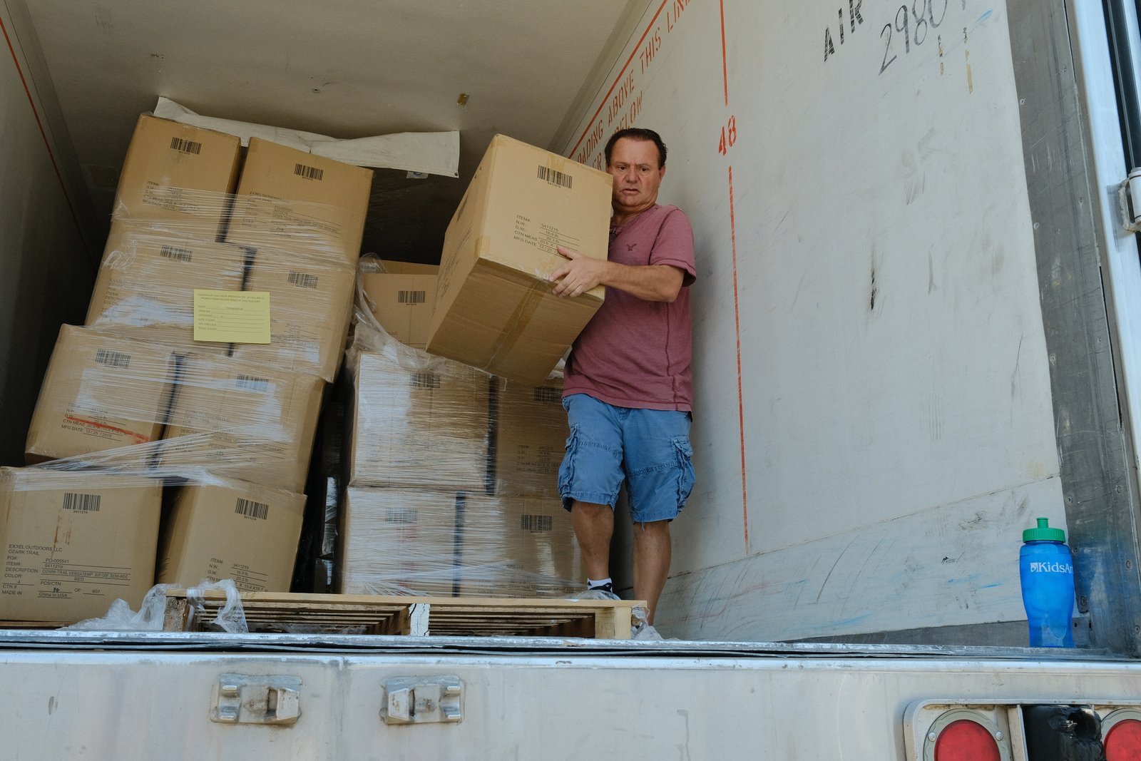 A Garni volunteer loading a box onto a relief truck